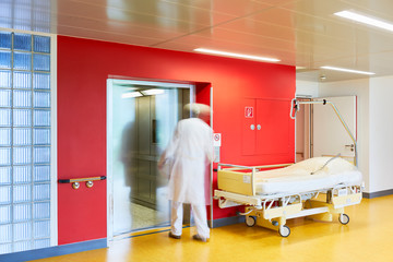 Krankenhaus Arzt eintreten in Aufzug gehend mirt Wand rot und Schiebetür öffnet sich 