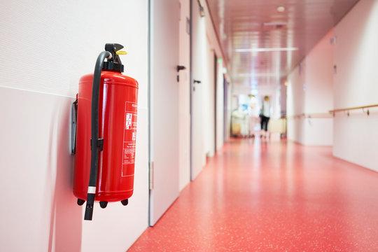 Krankenhaus mit Korridor Feuerl&ouml;scher und Frau unscharf in Zentralperspektive