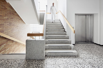 Krankenhaus mit Treppe und Aufzug mit Arzt und Bewegungsunschärfe hinunter laufen