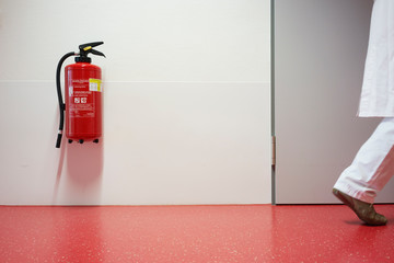 Krankenhaus mit Korridor Feuerlöscher und Frau unscharf in Zentralperspektive
