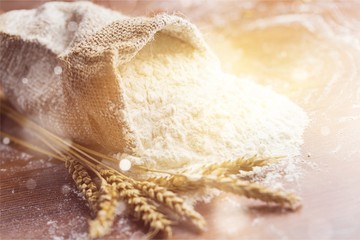 Wheat ears and flour on  background