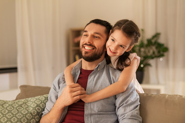 Fototapeta premium family, fatherhood, leisure and people concept - happy smiling father and little daughter hugging at home