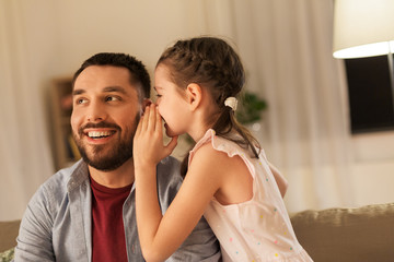 family, fatherhood, leisure and people concept - happy daughter whispering secret to father at home