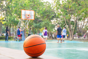 Basketball on the wooden chair Background Blurry image of people playing basketball on a court.
