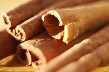 whole sticks of fragrant cinnamon, illuminated by the sun, in strong macro magnification
