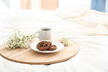 Tray with tasty breakfast on bed