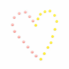 Heart shape made from colorful pills on white background. Concept