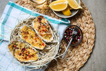 Plate with tasty baked oysters on table