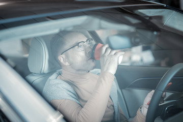 Businessman drinking coffee in the morning while driving to work