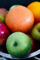 Washed apples, pears and oranges with water drops.