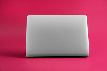 Modern laptop on color background