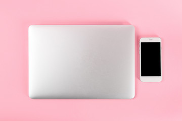 Modern laptop and mobile phone on color background