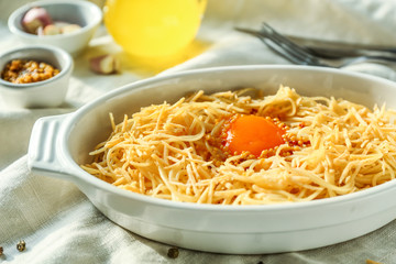 Dish with tasty pasta and egg on table