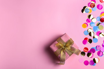 Beautiful gift box and confetti on color background