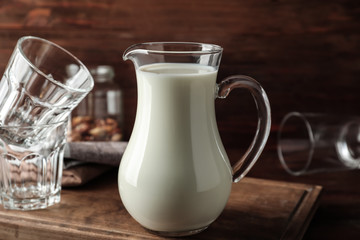 Jug of fresh milk on table