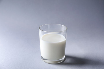 Glass of fresh milk on light background