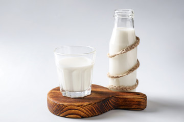 Glass and bottle of fresh milk on white background