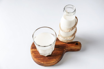 Glass and bottle of fresh milk on white background