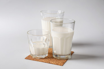 Glasses of fresh milk on white background