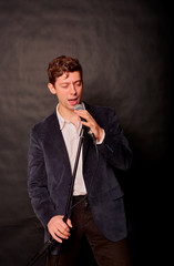 man sings on a dark background in the microphone