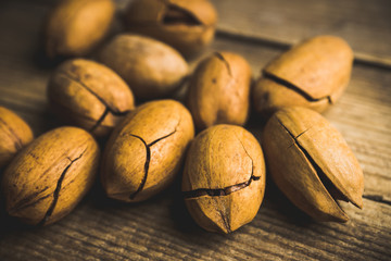 Delicious pecan nuts on the rustic wooden background. Selective focus. Shallow depth of field.
