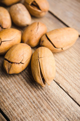 Delicious pecan nuts on the rustic wooden background. Selective focus. Shallow depth of field.