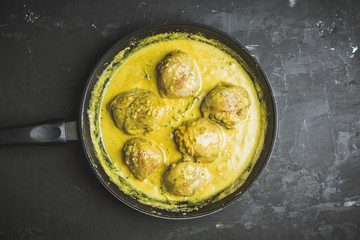 Roasted chicken in a pan with cream sauce and spices. Selective focus.