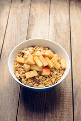 Healthy and tasty breakfast with muesli, apples, nuts and cinnamon. Selective focus.