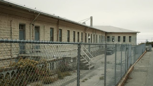 Camera moves close to fence around building on Alcatraz island