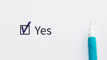 Yes - checkbox with a tick on white paper with blue pen. Checklist concept.