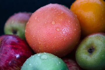 Washed apples, pears and oranges with water drops.