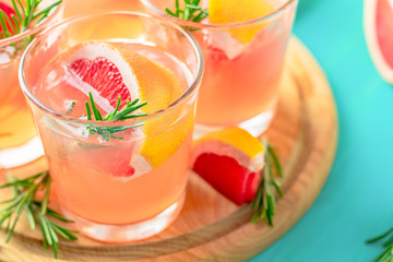 Pink alcoholic cocktail with grapefruit, ice and mint