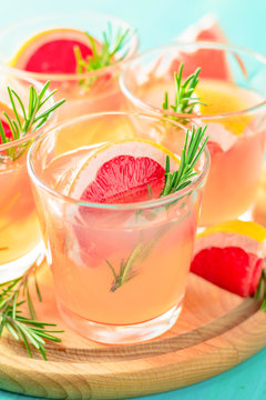 Pink alcoholic cocktail with grapefruit, ice and mint