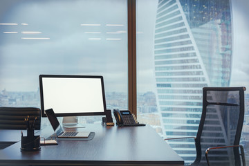 Computer with blank screen and laptop on the working place in th