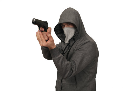 The man and in a mask on a face keeps a gun in a sports jacket before himself. White background