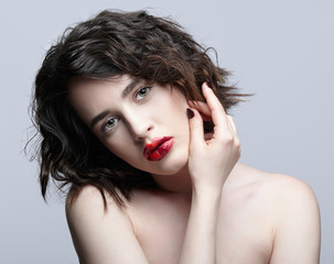 Brunette girl with unusual alyapy red female face makeup