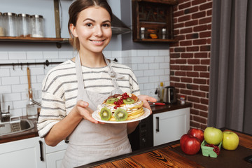 Happy young woman at the kitchen at home