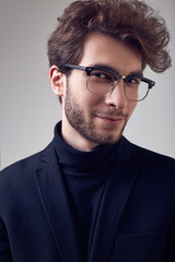Obraz premium Handsome elegant man with curly hair wearing suit and glasses