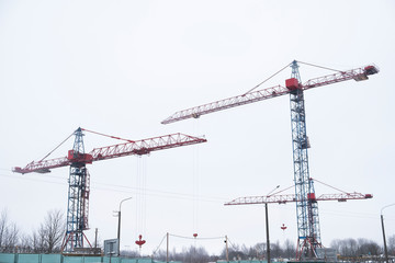 Fototapeta na wymiar Red construction tower crane. Two cranes construction
