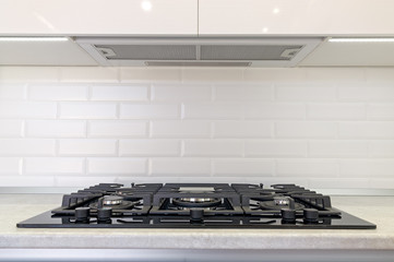 Gas stove and exhaust hood in the kitchen.