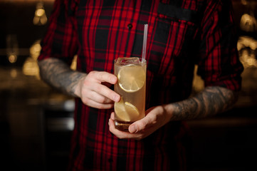 Professional bartender serving a glass of a Lemonade cocktail