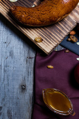 Bread fruits and jam on the scratched wooden cutting board.