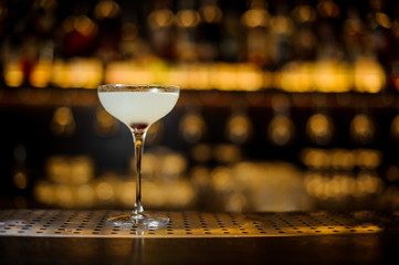 Glass of a Courpse Reviver cocktail on the wooden bar counter