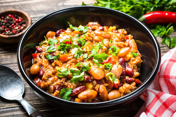 Chili con carne from meat and vegetables on wooden table top vie