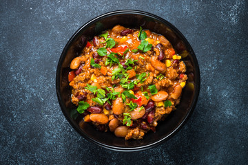 Chili con carne from meat and vegetables on black table top view