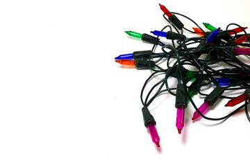 Multi-colored blinking light bulbs with coiled cables placed on a white background
