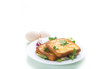 fried croutons in eggs with greens in a plate