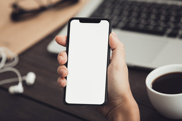 Hand using new smartphone on workplace background