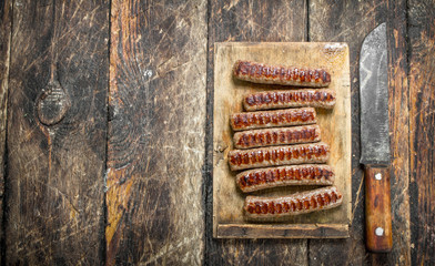 Grilled sausages on wooden table.