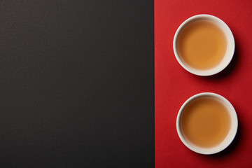 top view of tea cups on red and black background with copy space